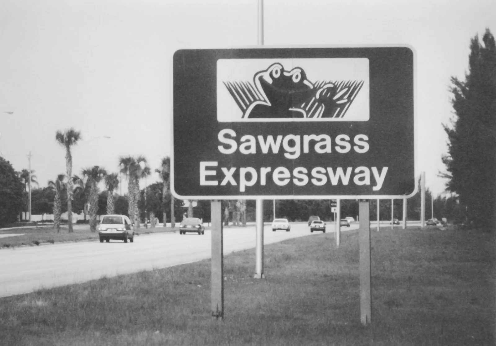 Traffic passing a Sawgrass Expressway sign in South Florida